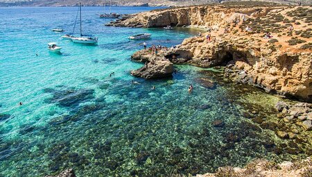 Drone of people in the clear waters of Blue Lagoon, Malta
