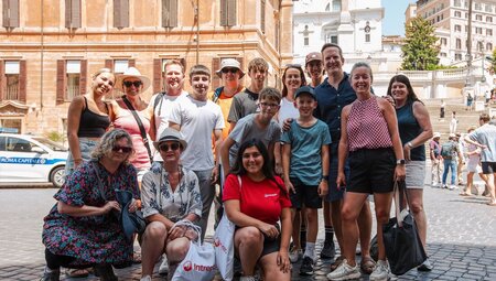 Group of family travellersa and leader pose for a group shot in the sunny streets of Rome Italy