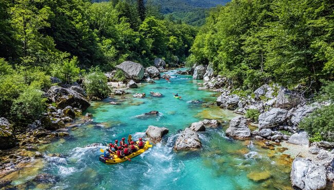 Intrepid travellers rafting down the Soca River with kayak guides in Slovenia
