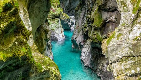 The depths of Tolmin Gorges with crystal blue waters running through wind carved stone walls