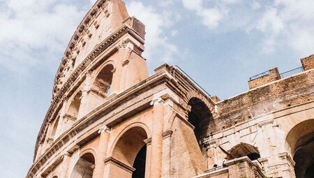 Looking up at the architecture of the Colosseum in Rome, the capital of Italy with a sky backdrop