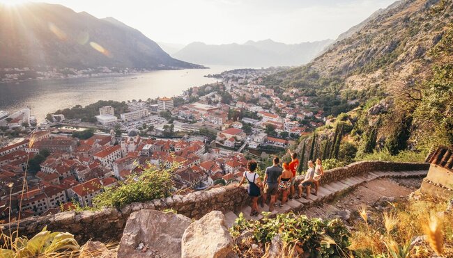 Travellers enjoying the view with a leader who is pointing off in the distance in Kotor, Montenegro
