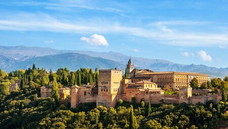 The epic exterior of the Alhambra Palace in the green hills of Granada, Spain