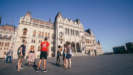 18 to 35s travellers listen to a talk from Intrepid leader outside Hungarian Parliament in Budapest on sunny day