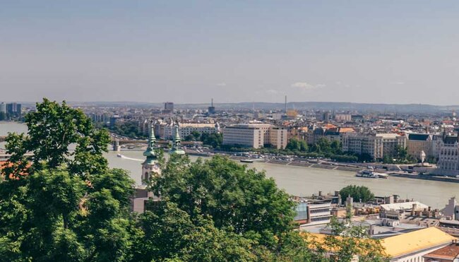 Tour group on balcony looks over river between Buda and Pest