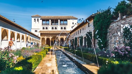 Alhambra Palace interior with running fountains in a gently curated garden outside Granada, Spain
