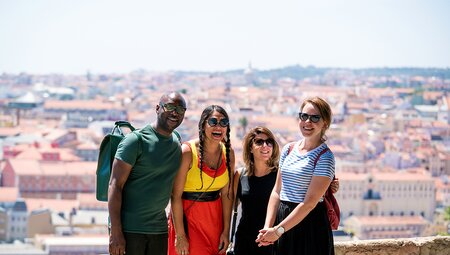 Group of Intrepid travellers laughing with city view in Lisbon, Portugal