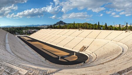 Wide view of empty Panathenaic Stadium on sunny day with fluffy white clouds, Athen, Greece