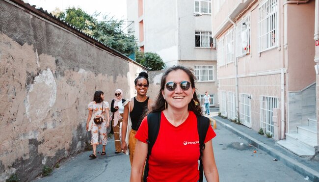 Intrepid leader smiles leading a group of travellers through the streets of Istanbul in Turkey