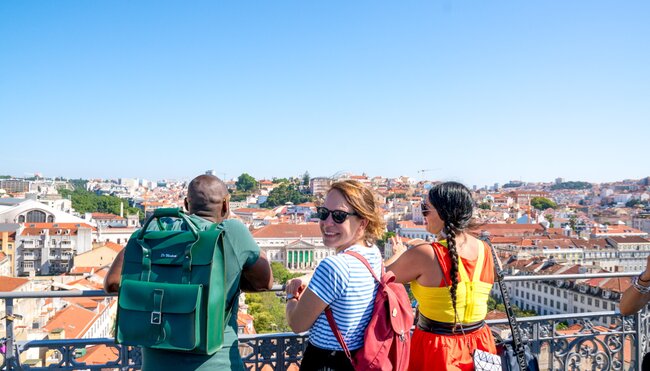 Intrepid travellers look out over Lisbon and smile back on a sunny day in Portugal