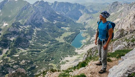 Man hiking in the mountains of Durmitor National Park overlooking Veliko Lake, Montenegro