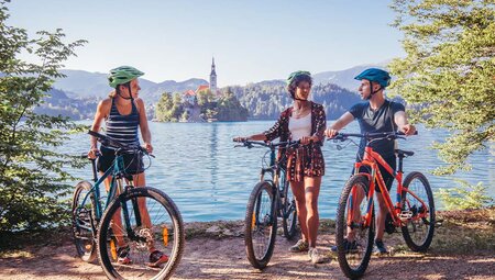 Travellers cycling in front of Lake Bled, Slovenia