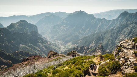 Two travellers come up the mountainside, hiking to Pico do Ruivo on Madeira island in Portugal