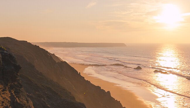 Traveller hiking along coastline of Rota Vicentina at sunset, Portgual
