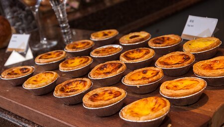 Portugese Custard Tarts in a local shop front window in Lisbon, Portugal.