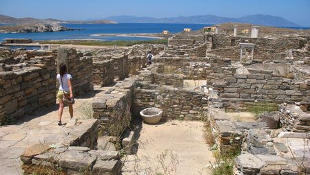 Walking throught the stone walled footprints of Greek ruins of Delos island in the Cyclades