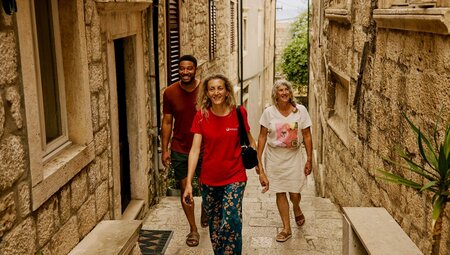 Leader walking with travellers in a small, cobblestone street in Korcula, Croatia