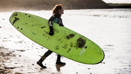Frau mit Surfboard in St. Davids