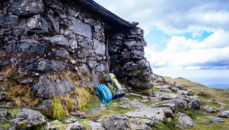 Rucksäcke vor einer Hütte bei Rast