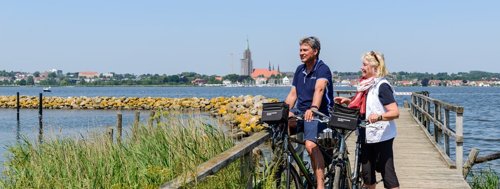 Zwei Radfahrer bei der Pause auf einem Steg an der Ostsee