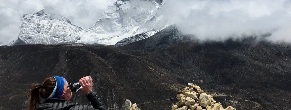 Trailrunnerin mit Wasserflasche im Himalaya