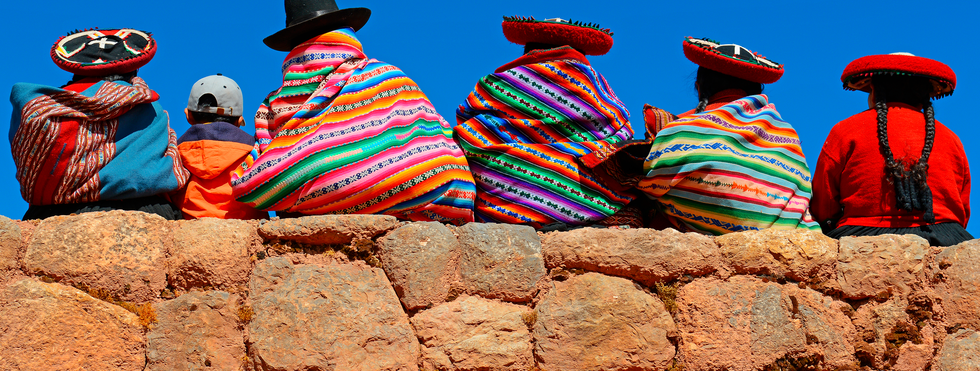 Quechua sitzend auf einer Mauer