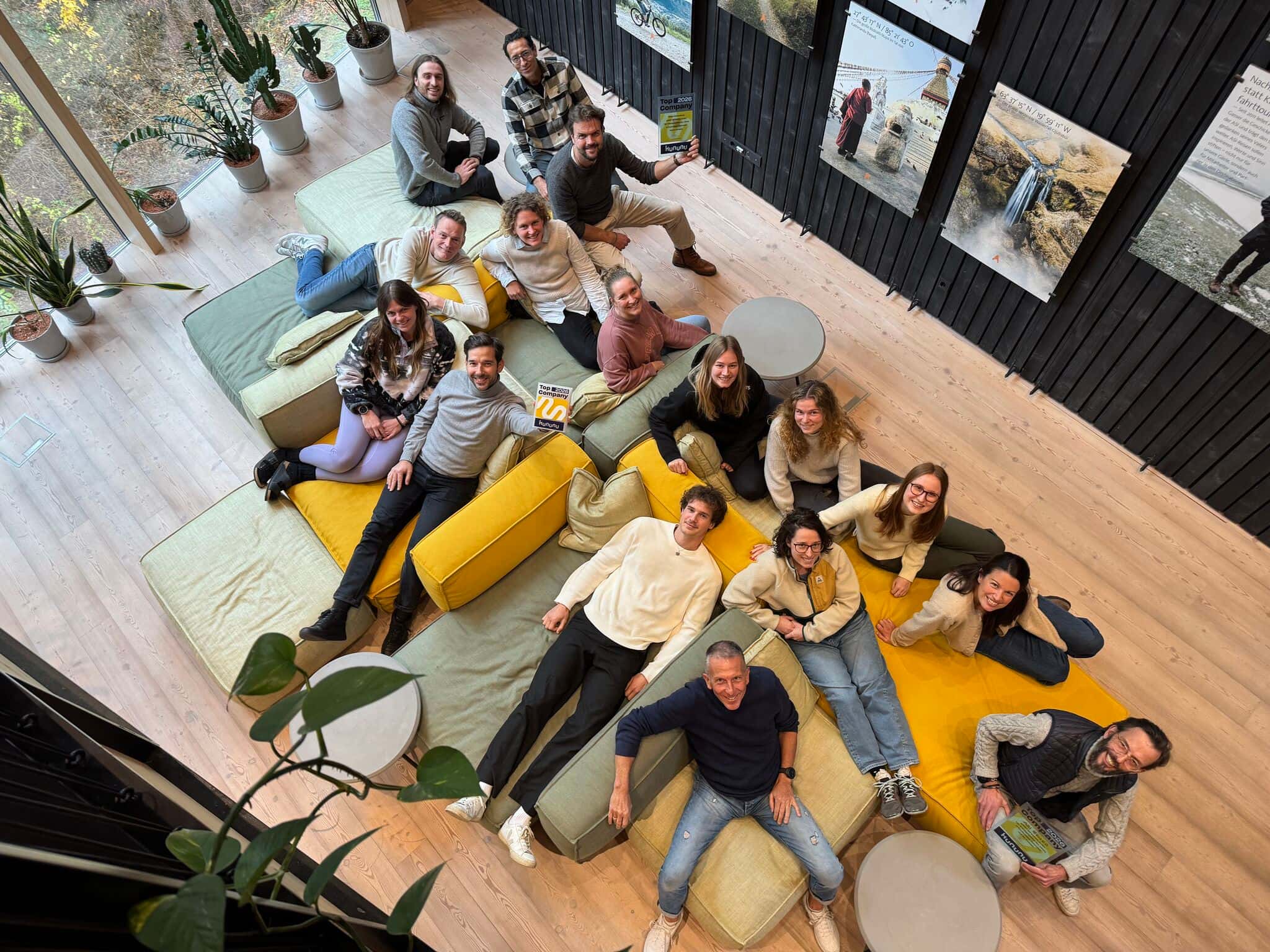 ASI Reisen Mitarbeitende gemeinsam in einem modernen Office-Loungebereich.