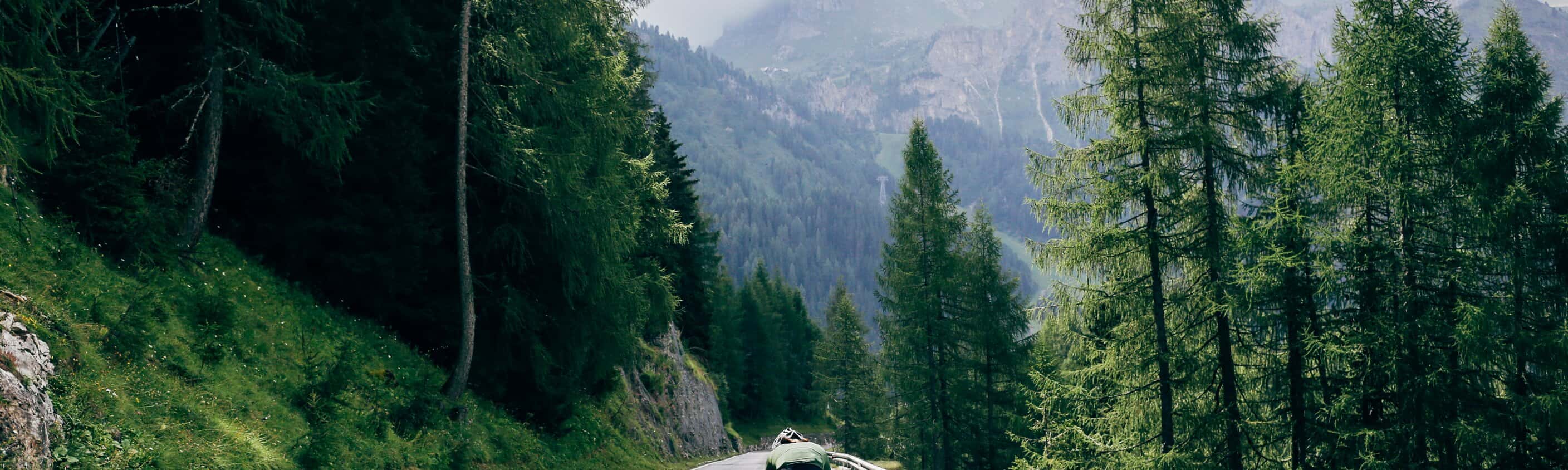 Professioneller Radfahrer mit schnellem und leichtem Kohlenstoff-Fahrrad steigt in den Alpen-Dolomiten auf die Bergstraße ab. | © Shutterstock