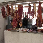 Abhängendes Fleisch und Junge im Hintergrund