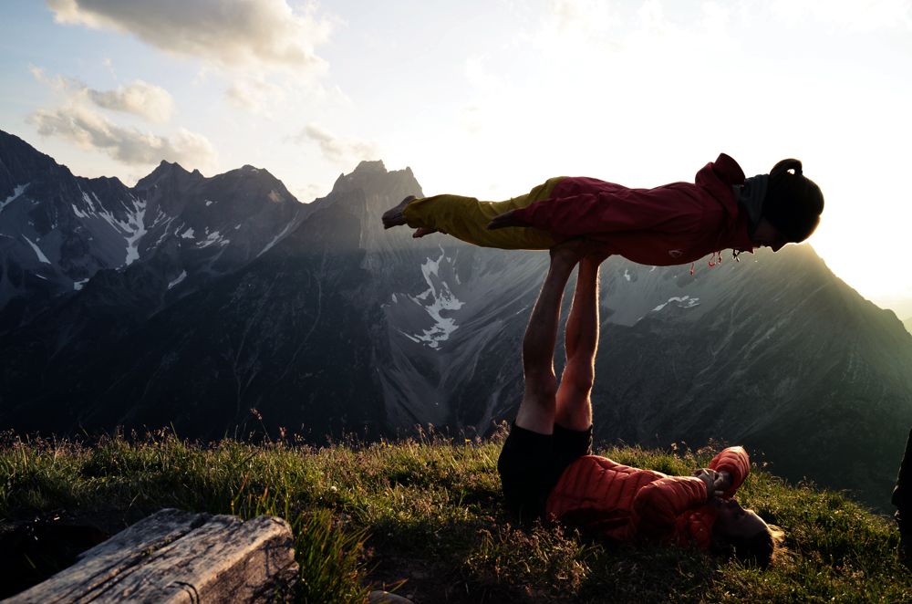 Acroyoga beim Sonnenuntergang bei der Alpenüberquerung