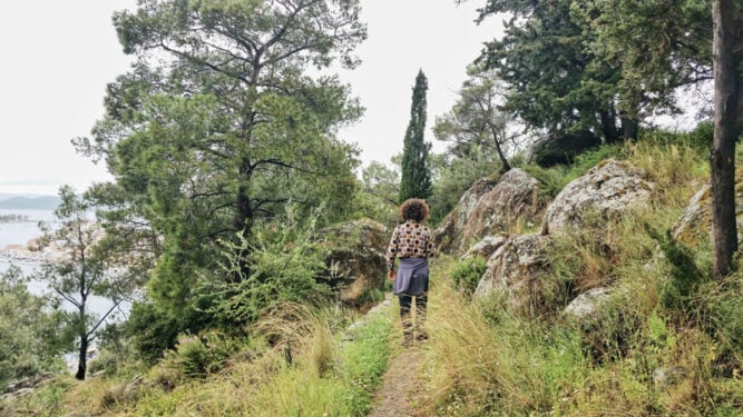 Wanderin auf schmalem Wanderpfad in einem Wald