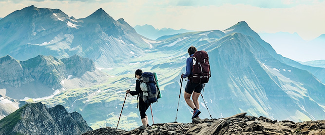 Zwei Frauen wandern vor Gletscherpanorama in der Schweiz