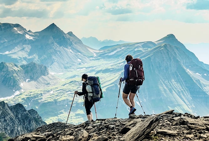 Zwei Frauen wandern vor Gletscherpanorama in der Schweiz