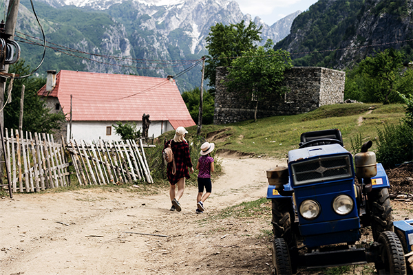 Häuser und Traktor auf dem Land in den albanischen Alpen