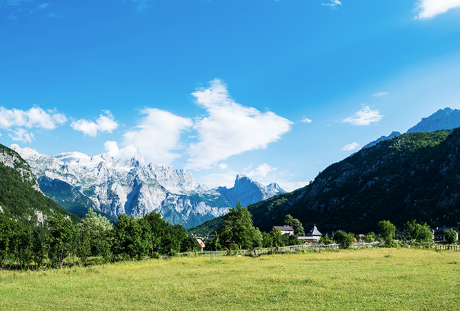 Grüne Wiesen und Bergblick am Zehnten Wanderweg