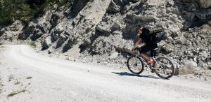 Person auf Fahrrad auf einem Schotterweg