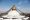 Die berühmte Bodnath Stupa in Kathmandu Goldener Spitzturm mit aufgemaltem Gesicht. Gebetsfahnen von der Turmspitze zu allen Seiten hinunter.