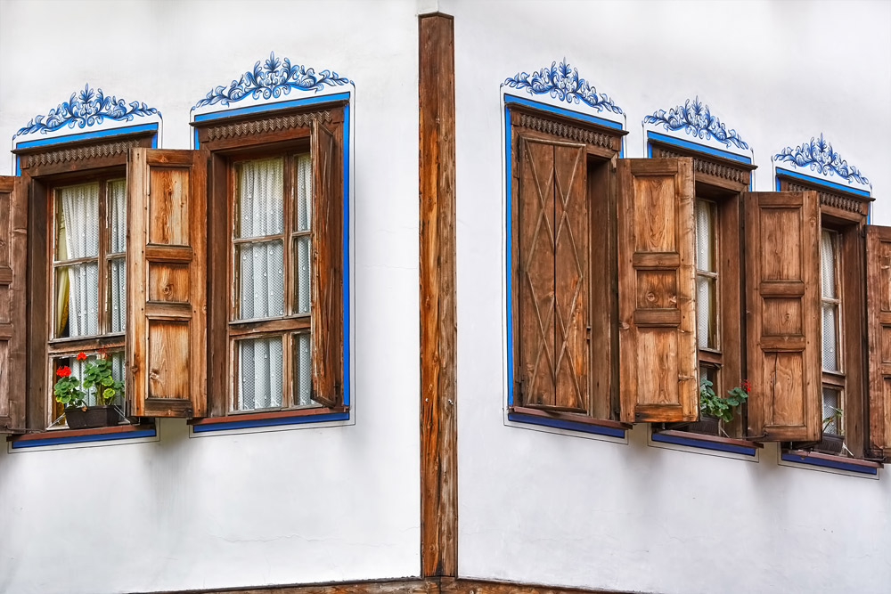 fensterläden aus holz auf weißer hausfassade