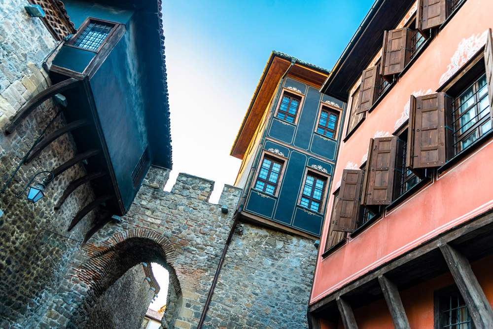 blick nach schräg oben auf stadtmauer und bunte häuserfassaden