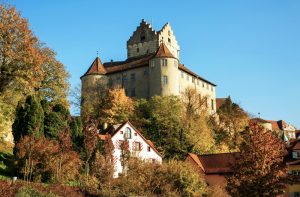 Eine alte Burg auf einem Hügel, Laubbäume herum, Herbst