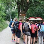 Gruppe Menschen steht vor Theke mit Getränken im Wald