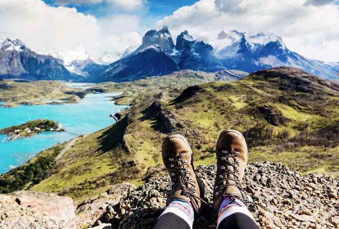 Mädchen-Wanderstiefel und Ausblick auf die Berge von Los Cuernos in Patagonien, Chile