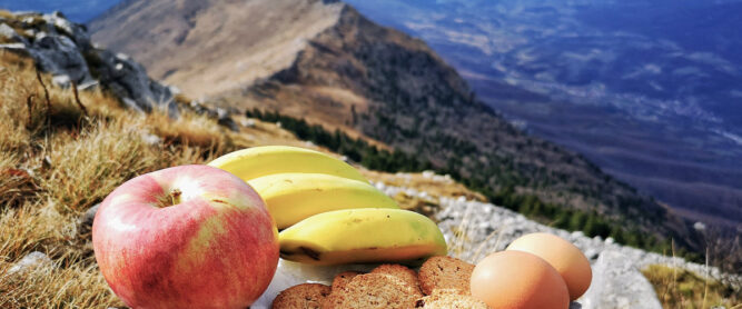 Obst, Brot und Eier auf einem Gipfel. Blick ins Tal