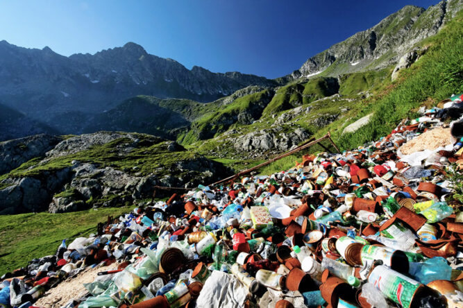 Große Mengen an leeren Plastikflaschen und Müll auf grünen Bergwiesen