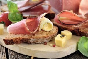 Ein Holzbrett mit Speck, Käse und Brot darauf