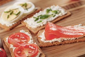 Bestrichene Brote mit Lachs und Tomaten