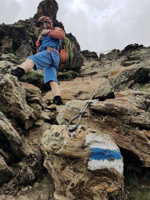 Bergführer mit rotem Helm und Rucksack, Schweiz