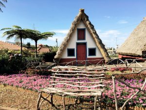 Traditionelles Haus mit Blumen und Holzbank