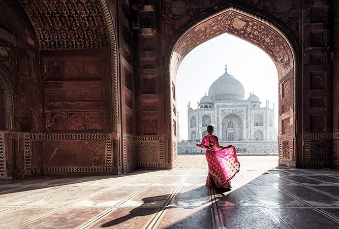 Eine Frau steht in einem Sari in einem Tempel in Indien