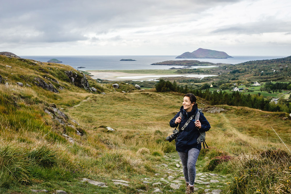 frau in grüner landschaft mit meer im hintergrund